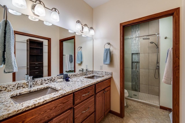 full bathroom featuring a stall shower, double vanity, a sink, and tile patterned floors