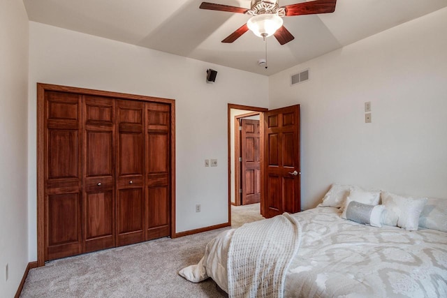 bedroom with a closet, visible vents, a ceiling fan, light carpet, and baseboards