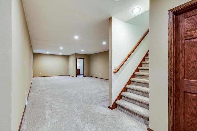 interior space featuring light carpet, stairway, baseboards, and recessed lighting