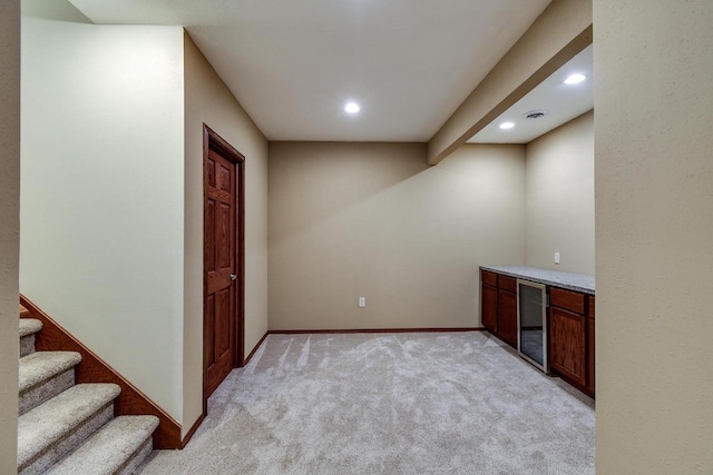 bar with recessed lighting, beverage cooler, light colored carpet, visible vents, and baseboards