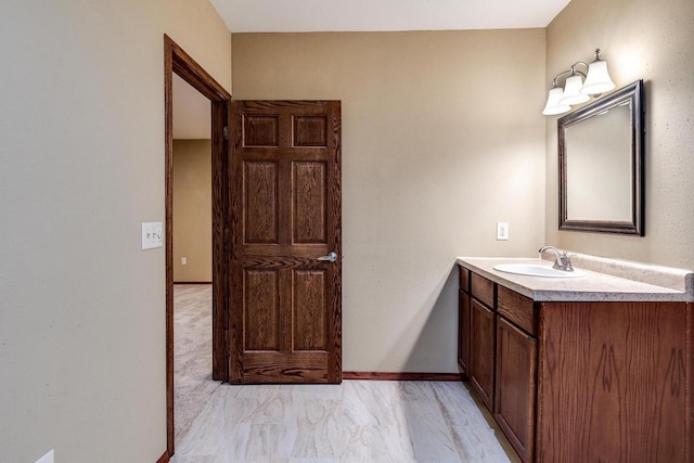 bathroom featuring marble finish floor, vanity, and baseboards