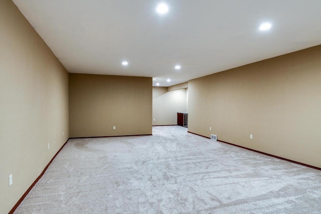 unfurnished room with light colored carpet, recessed lighting, visible vents, and baseboards