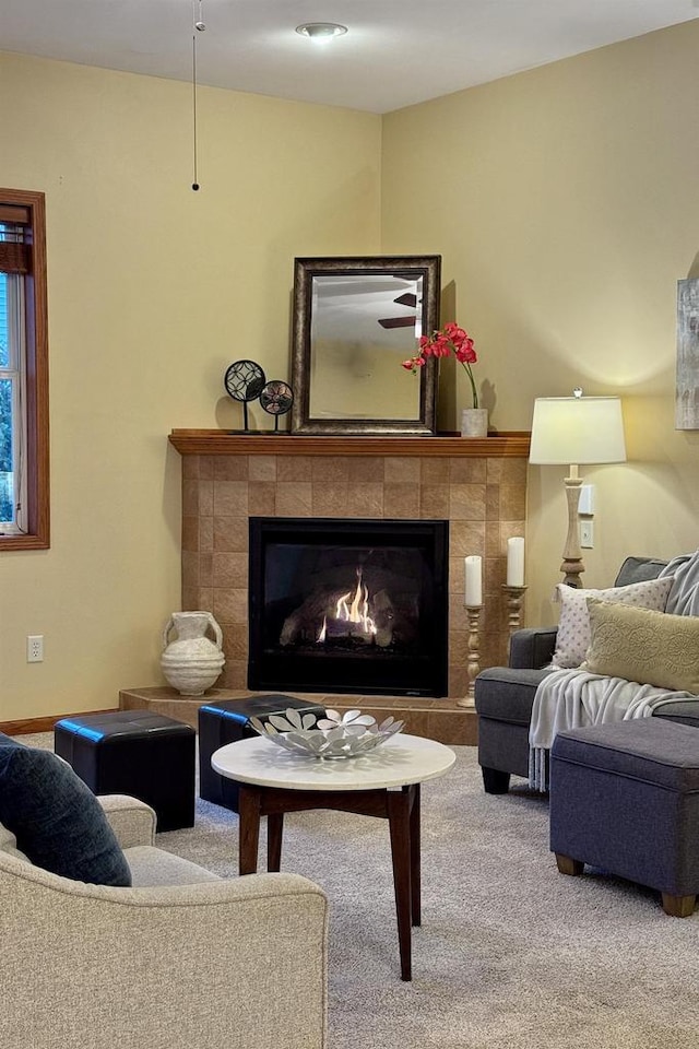 carpeted living room featuring a tile fireplace