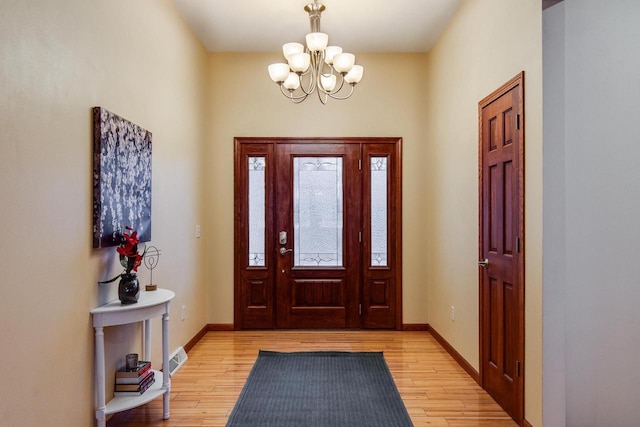 entryway with light wood-type flooring, visible vents, a notable chandelier, and baseboards