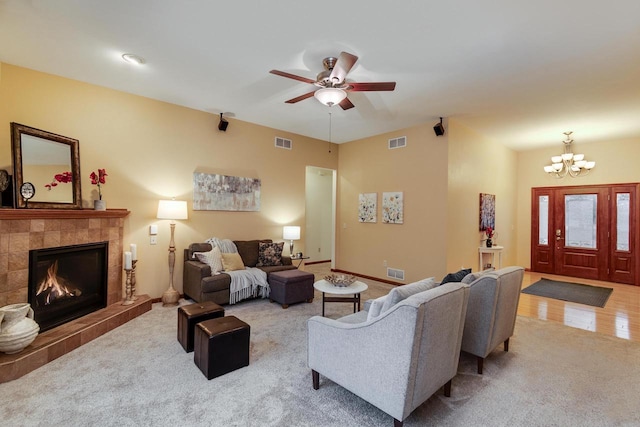 carpeted living area with baseboards, visible vents, and a tile fireplace