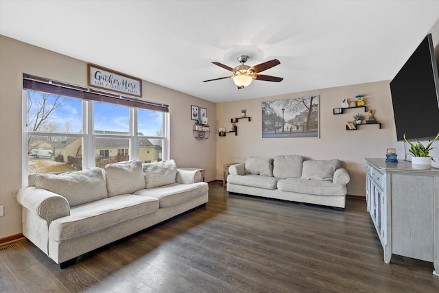 living area featuring a ceiling fan, dark wood-style flooring, and baseboards