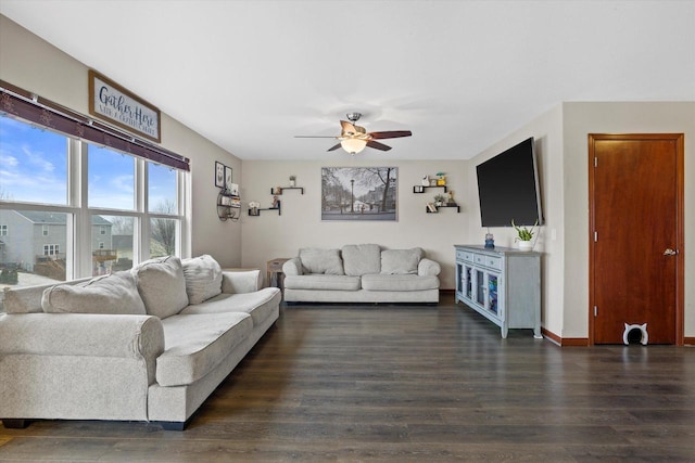 living room featuring ceiling fan, baseboards, and dark wood-type flooring