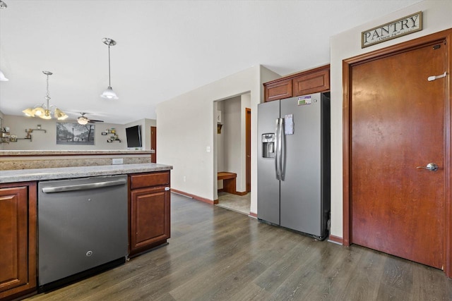 kitchen with light countertops, appliances with stainless steel finishes, dark wood-style flooring, and hanging light fixtures