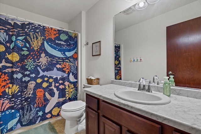 bathroom with toilet, visible vents, vanity, and tile patterned floors