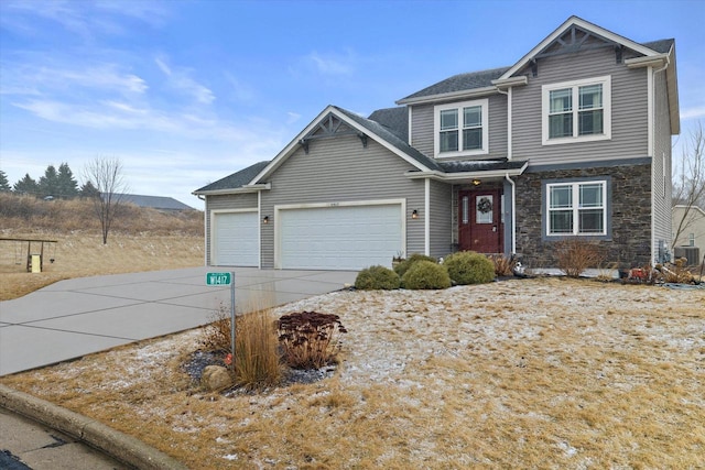 traditional-style home with an attached garage, stone siding, driveway, and central AC