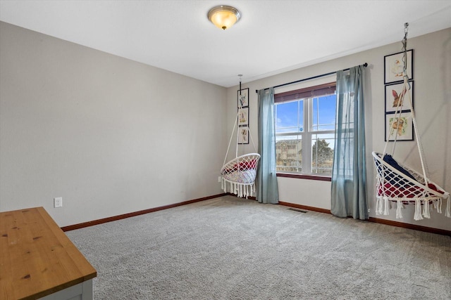 unfurnished room featuring carpet floors, visible vents, and baseboards