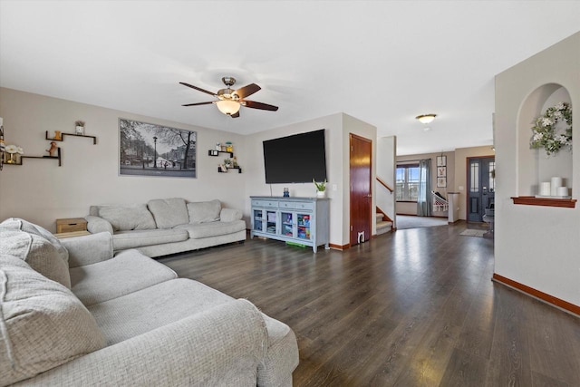 living area featuring dark wood-style floors, baseboards, stairway, and a ceiling fan