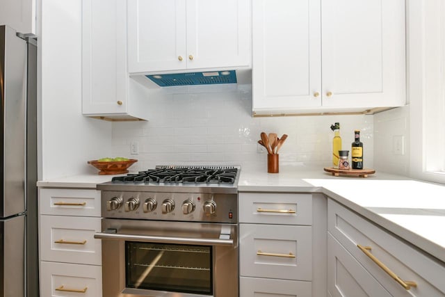 kitchen featuring white cabinetry, stainless steel appliances, decorative backsplash, and light countertops