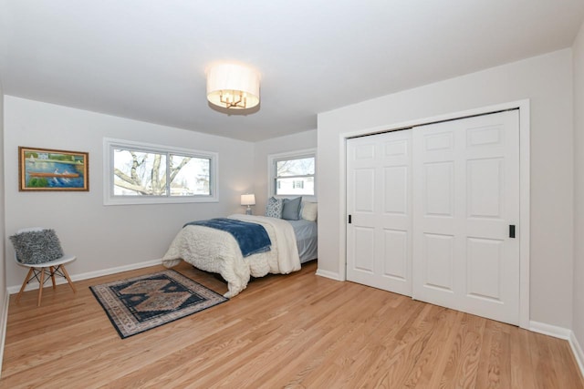 bedroom featuring light wood-type flooring, a closet, and baseboards