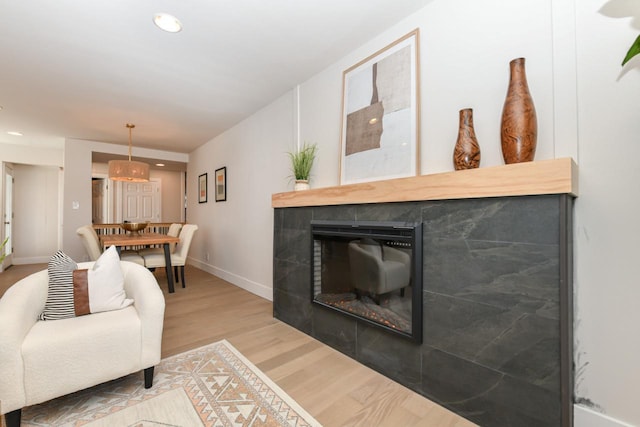 living room featuring recessed lighting, a fireplace, and wood finished floors