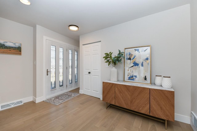 entrance foyer with light wood-style floors, baseboards, and visible vents