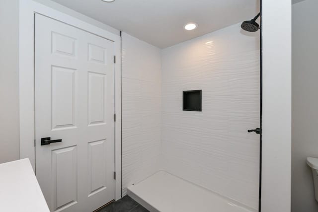 bathroom featuring walk in shower, toilet, and recessed lighting