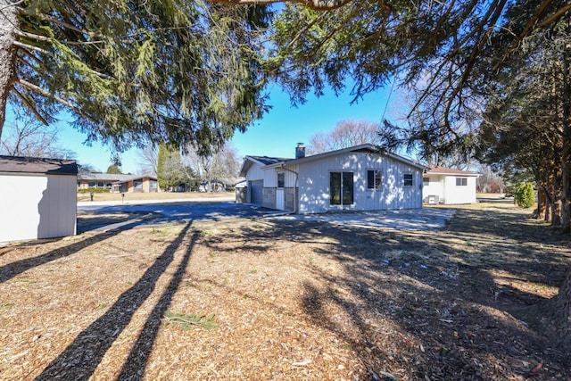 exterior space with an outbuilding, a chimney, and a shed