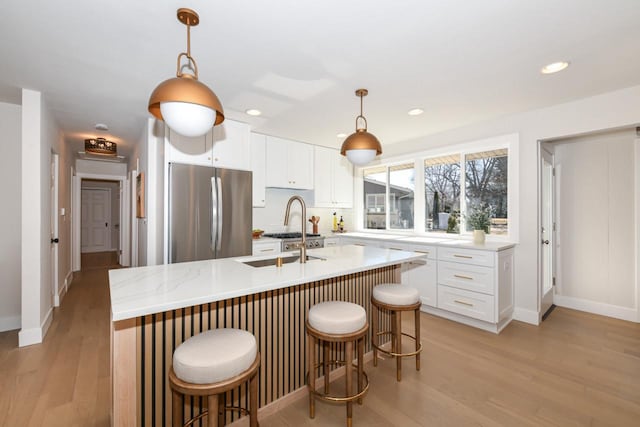 kitchen with white cabinetry, freestanding refrigerator, and light wood-style floors