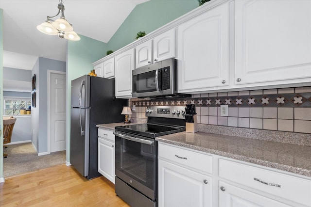 kitchen featuring lofted ceiling, white cabinetry, appliances with stainless steel finishes, and tasteful backsplash