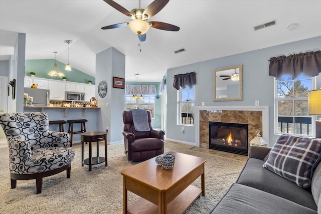 living area featuring visible vents, a ceiling fan, light colored carpet, lofted ceiling, and a premium fireplace