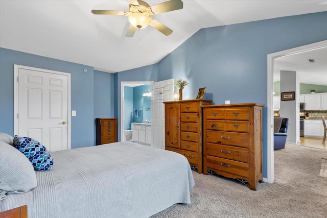 carpeted bedroom with lofted ceiling, ensuite bath, and a ceiling fan