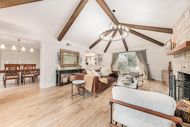 living room with vaulted ceiling with beams, a notable chandelier, a fireplace, visible vents, and light wood finished floors