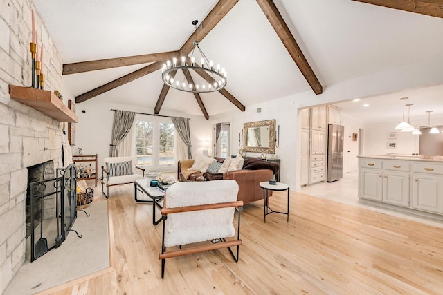 living area with lofted ceiling with beams, a stone fireplace, and light wood finished floors