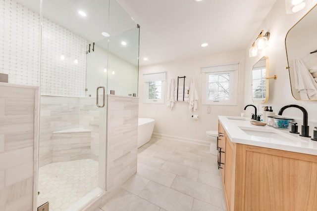 bathroom with a stall shower, a sink, a freestanding bath, and double vanity