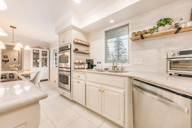 kitchen with tasteful backsplash, appliances with stainless steel finishes, crown molding, open shelves, and a sink