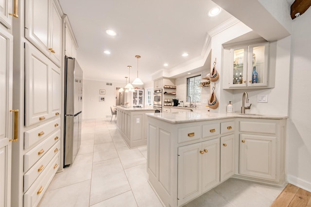 kitchen featuring stainless steel appliances, light countertops, ornamental molding, a sink, and a peninsula