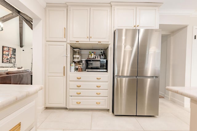 kitchen featuring appliances with stainless steel finishes, white cabinets, light tile patterned flooring, and ornamental molding