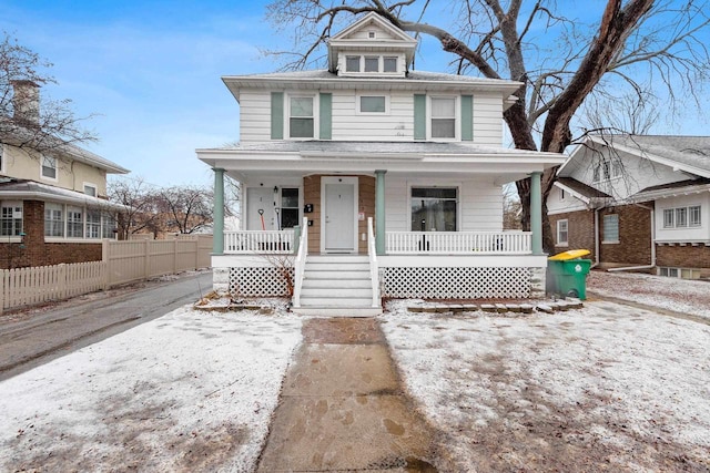 american foursquare style home with covered porch and fence