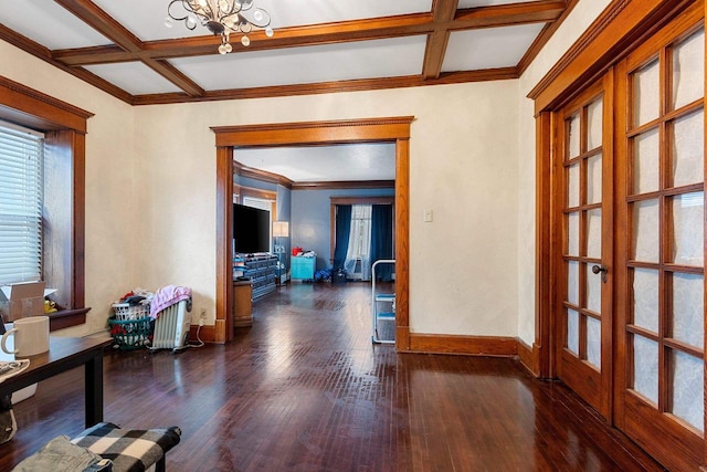 interior space with dark wood-type flooring, a chandelier, coffered ceiling, and baseboards