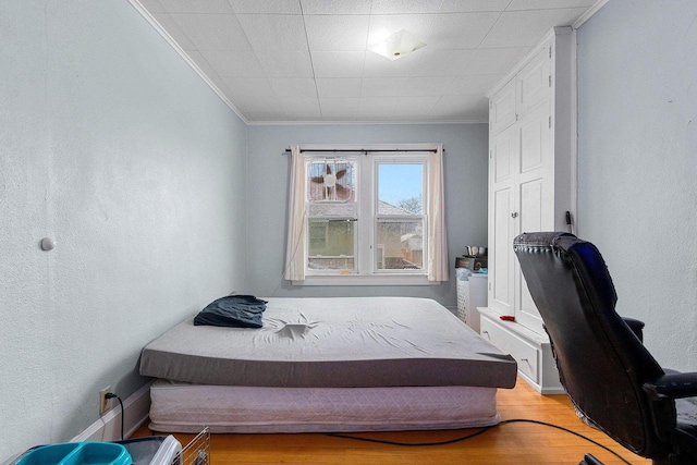 bedroom featuring ornamental molding and light wood-type flooring