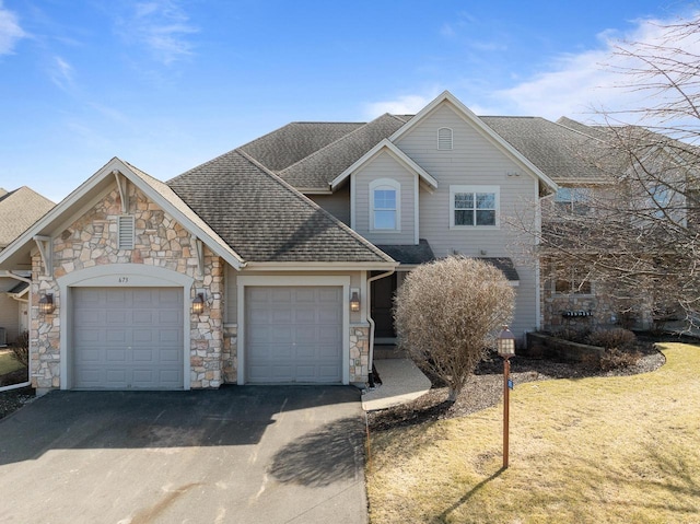 view of front of home featuring an attached garage, driveway, and a shingled roof