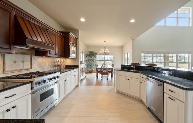 kitchen with tasteful backsplash, decorative light fixtures, an inviting chandelier, stainless steel appliances, and a sink