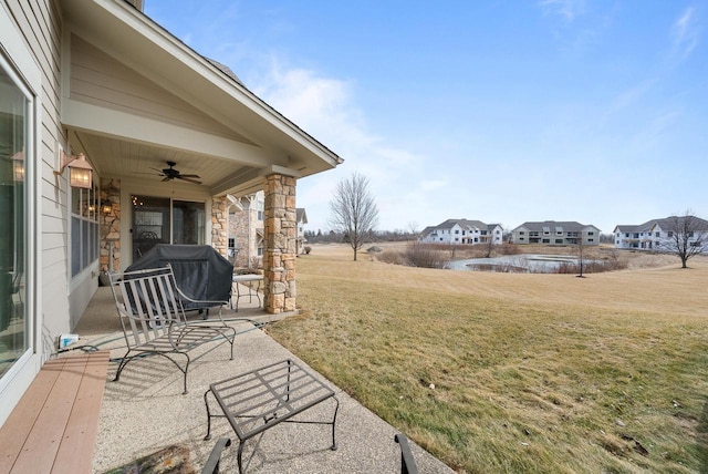 view of yard featuring ceiling fan, a patio area, and a residential view