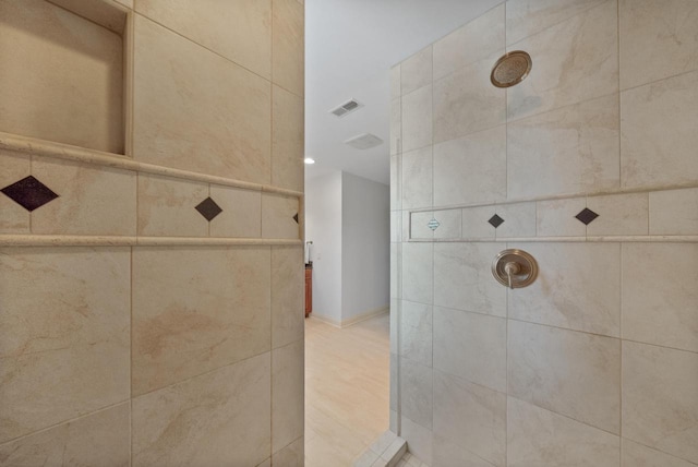 bathroom featuring tiled shower and visible vents