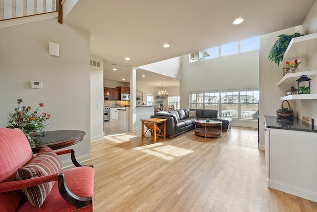 living room with light wood finished floors, visible vents, a chandelier, and recessed lighting