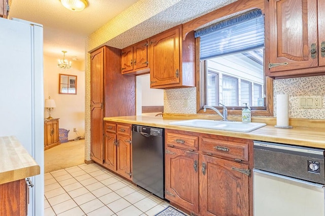 kitchen with black dishwasher, dishwasher, brown cabinets, light countertops, and a sink