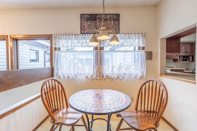 dining area with a chandelier and baseboards