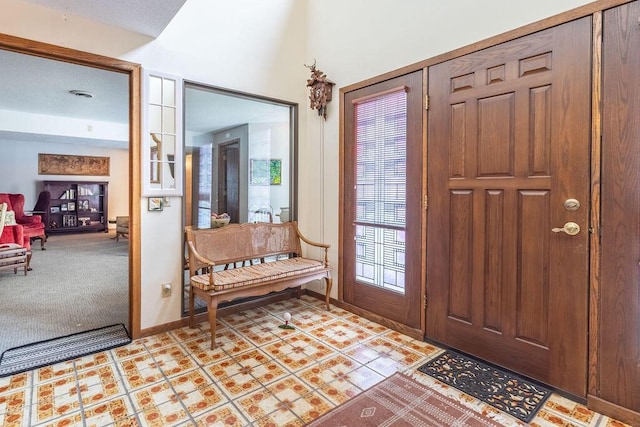 entrance foyer featuring baseboards, visible vents, and light colored carpet