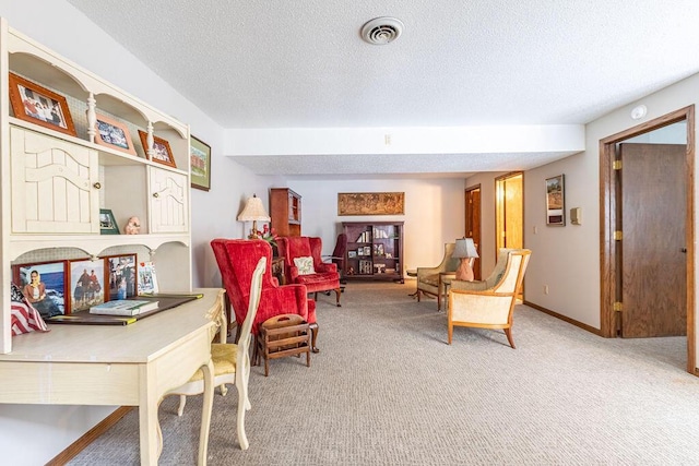 living area featuring a textured ceiling, carpet, visible vents, and baseboards