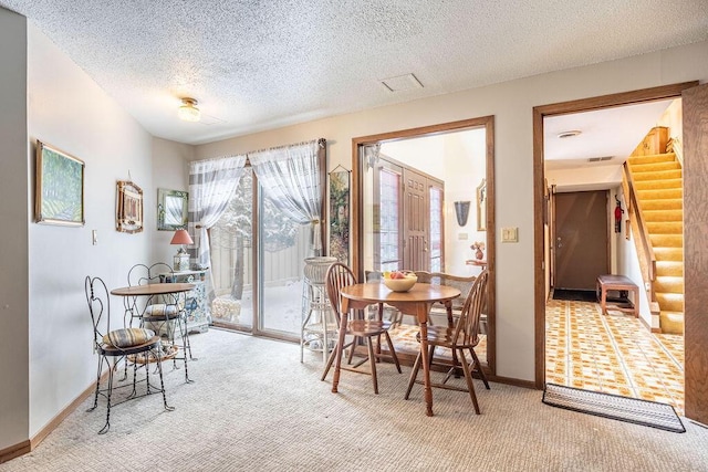 dining area with carpet, visible vents, a textured ceiling, baseboards, and stairs