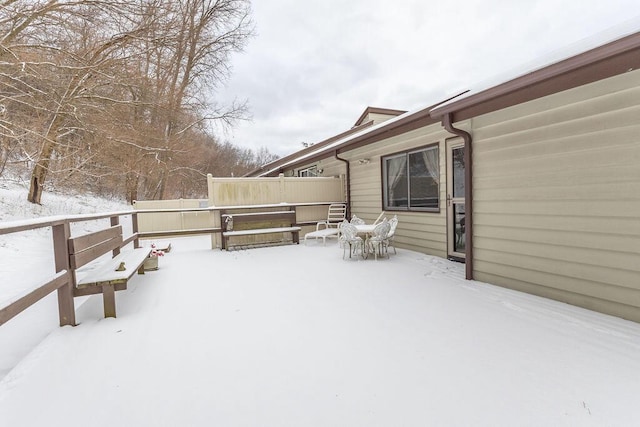 snow covered deck featuring fence