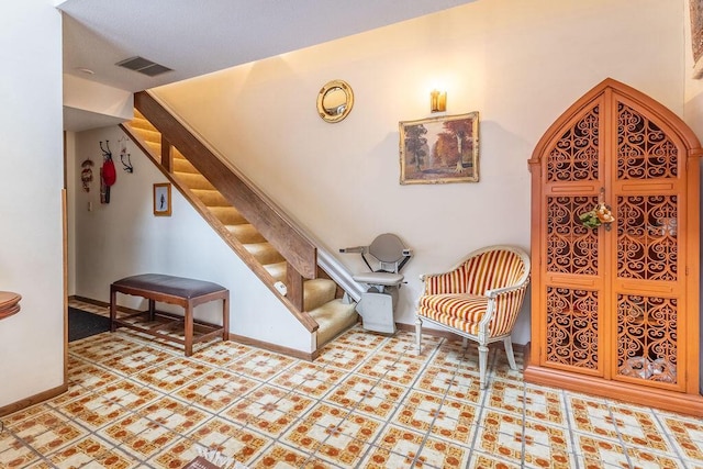 interior space featuring visible vents, baseboards, and stairs