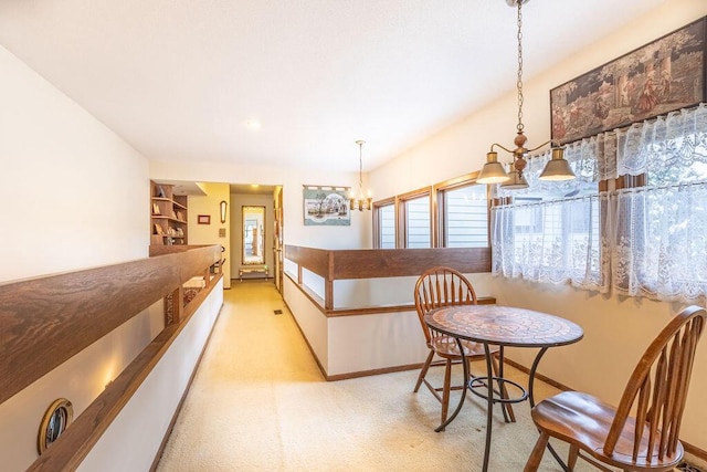 dining area with a notable chandelier, built in shelves, baseboards, and light colored carpet