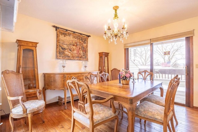 dining room featuring a notable chandelier, baseboards, and light wood-style floors