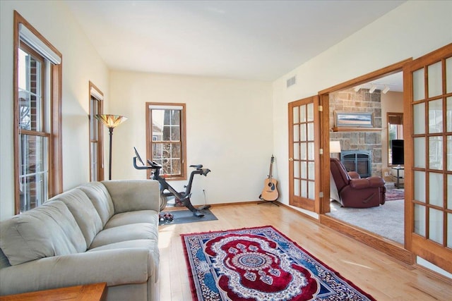 living area featuring visible vents, plenty of natural light, wood finished floors, and french doors